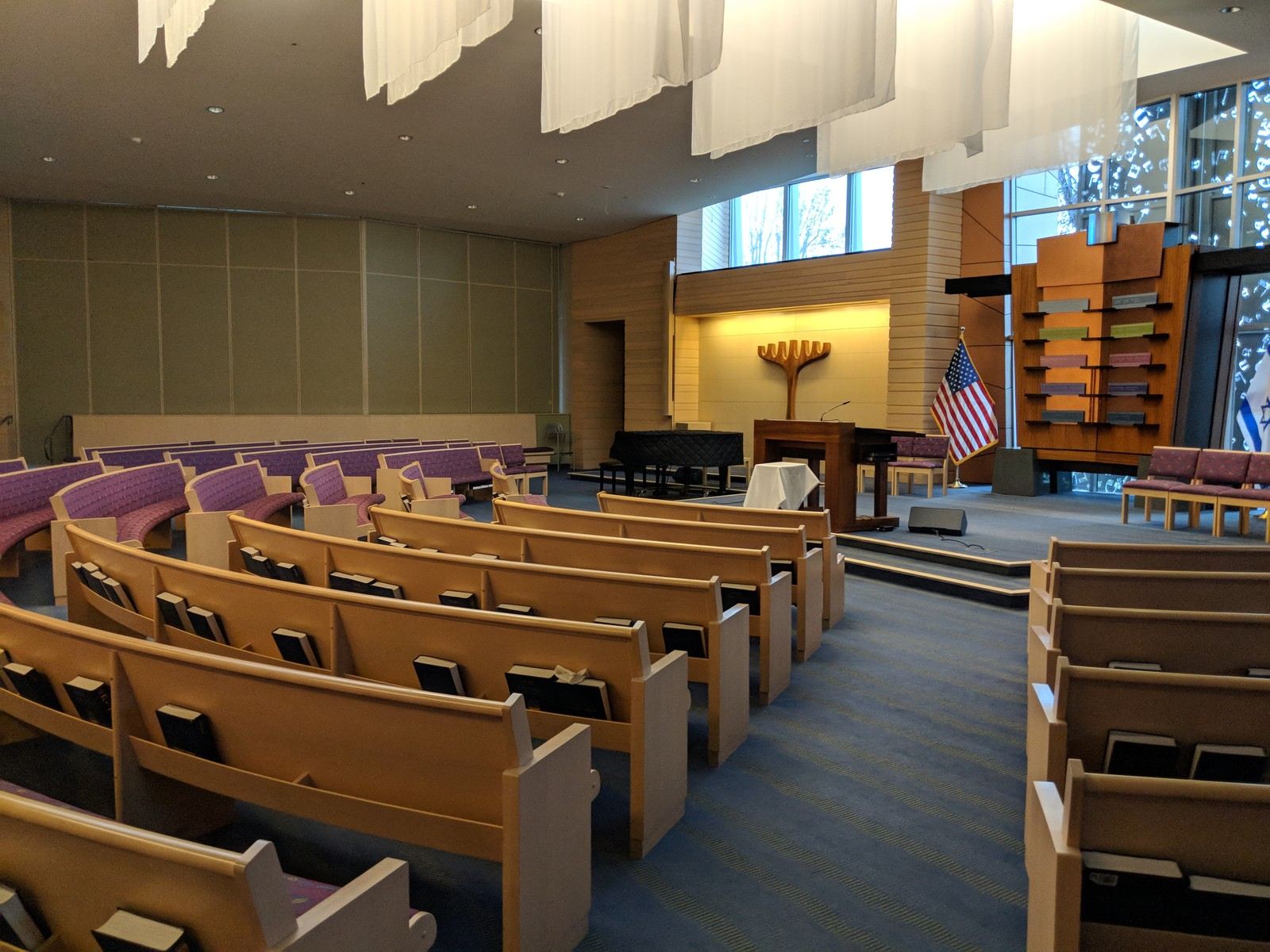 A synagogue entrance, with a menorah and Star of David sculpture beside the doors